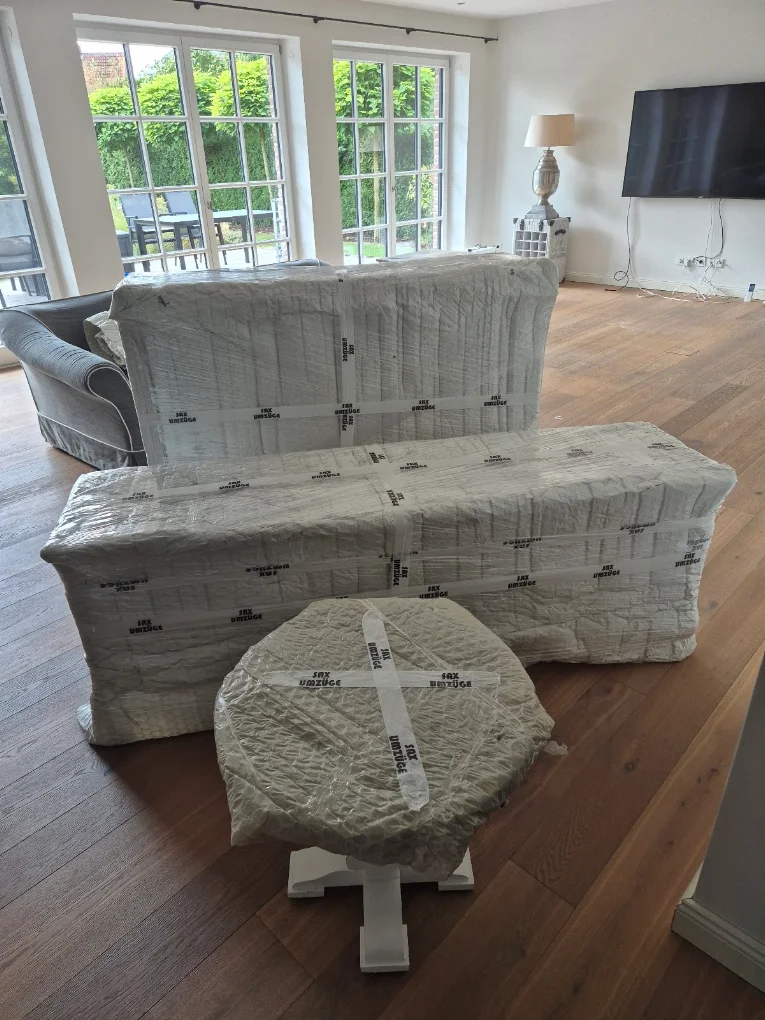 Geschützte Polstermöbel und verpackter kleiner Tisch im Wohnzimmer